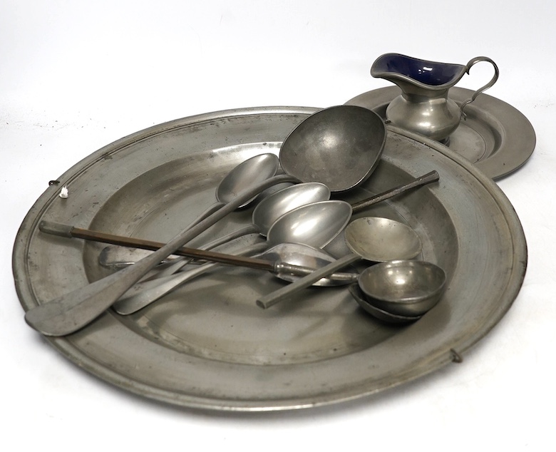 A quantity of 18th century and later pewter to include charger, warming plates and spoons, largest 39cm in diameter. Condition - mostly fair